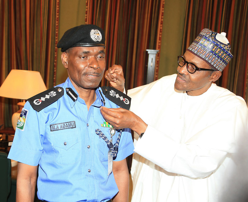 President Muhammadu Buhari decorates the new Inspector General of Police, Mr Mohammad Abubakar Adamu at the State House Abuja, on Tuesday, January 15, 2019.  PHOTO: SUNDAY AGHAEZE