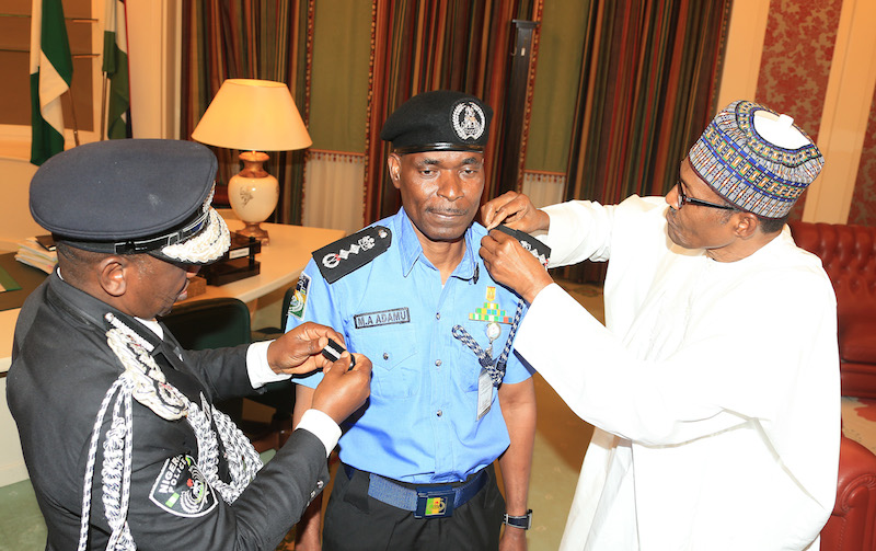 President Muhammadu Buhari decorates the new Inspector General of Police, Mr Mohammad Abubakar Adamu at the State House Abuja, on Tuesday, January 15, 2019.  PHOTO: SUNDAY AGHAEZE